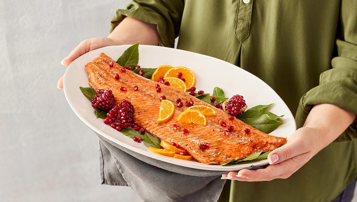 mediterranean menu woman holding platter cooked salmon hero