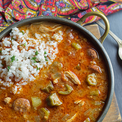 Overhead shot of chicken and sausage gumbo with a scoop of rice.