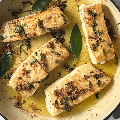 Brown butter halibut in a pan with sage